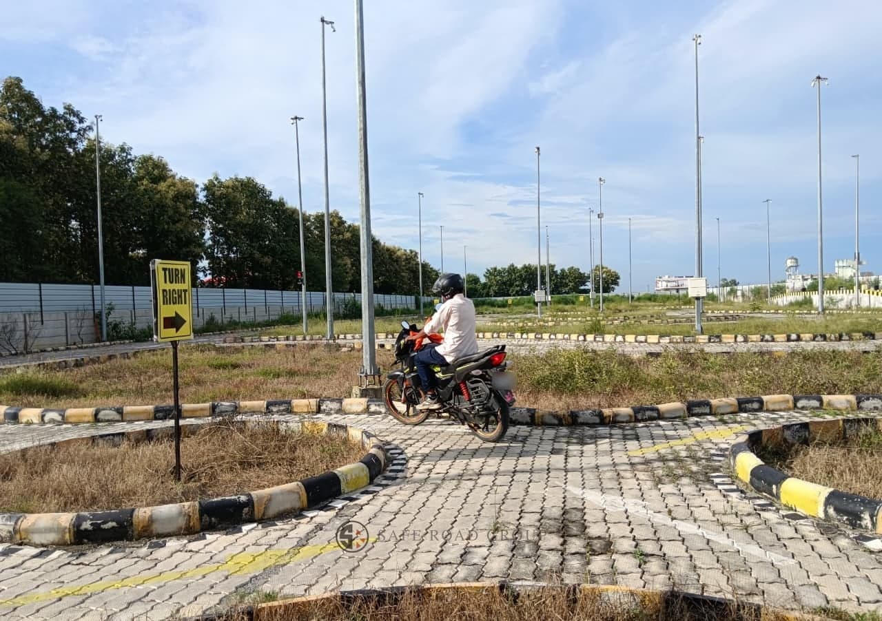 A rider taking the two-wheeler test on the circuit, helmeted